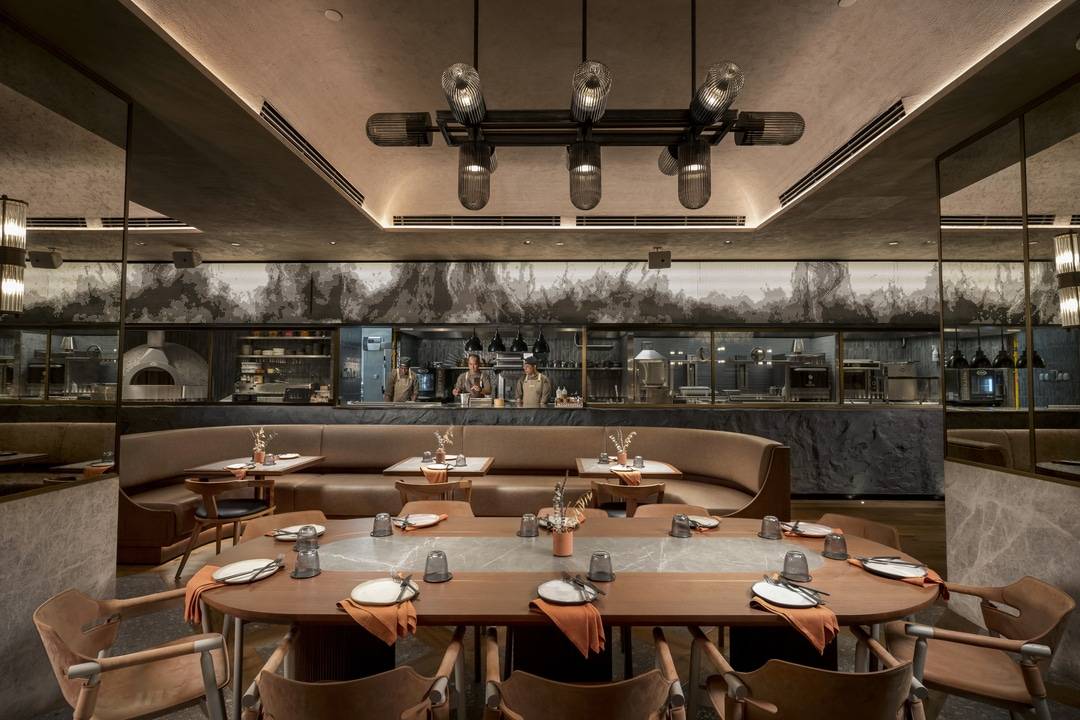 The 9th Cut: the live cooking station becomes a stage, crowned by a sculptural metal feature that mimics rising smoke